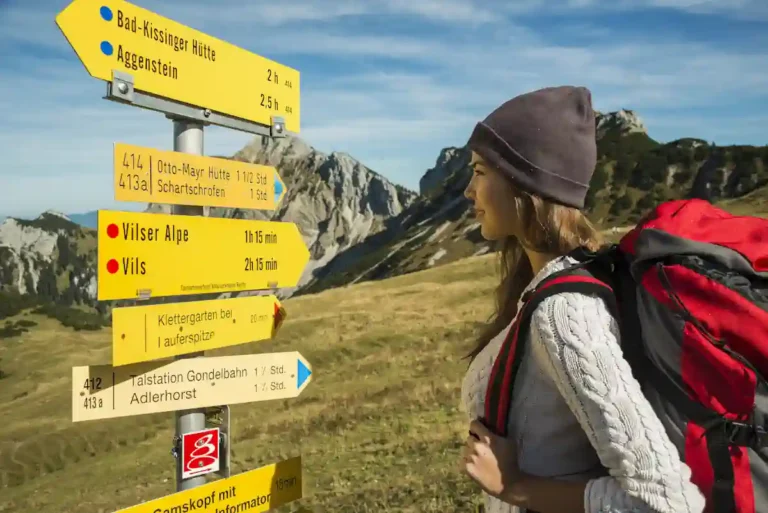 Une femme qui regarde des panneaux qui indiquent des routes