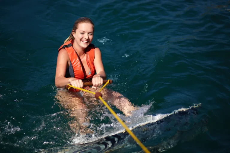 Une jeune femme dans l'eau sur une planche en train de tenir une corde