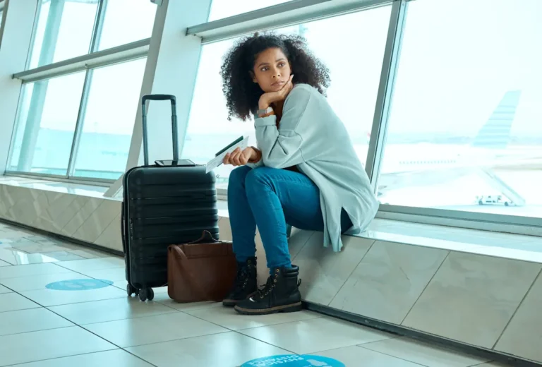 Une femme assise à côté de son valise